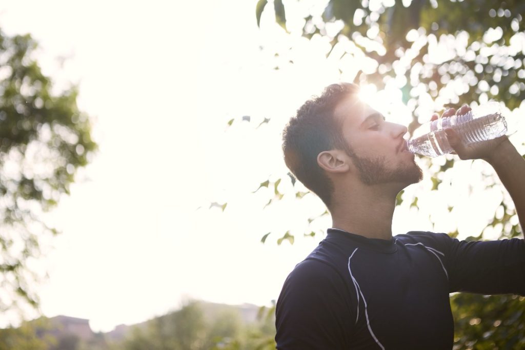 Un uomo che beve dell’acqua in bottiglia